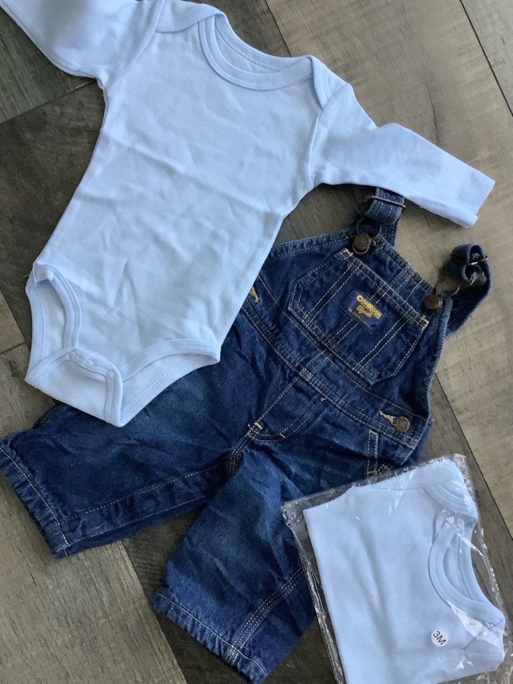 Oshkosh denim overalls, with two baby blue long sleeve onesies, size 3 months